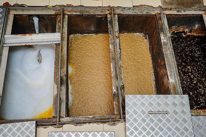 a grease trap being cleaned and emptied by a professional